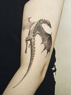 a woman with a dragon tattoo on her arm