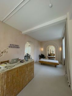 a large room with a desk and laptop on the counter in front of a mirror