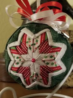 a green ornament with red and white designs on it sitting on a table