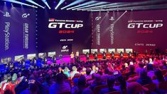 a large group of people sitting in front of a stage at a gaming convention with the words gt cup on it