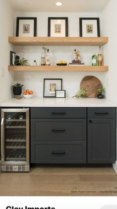 a kitchen with black cabinets and shelves filled with bottles, wine glasses, and other items