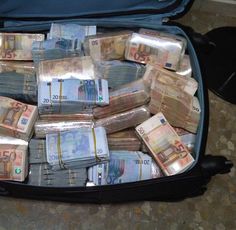 a suitcase filled with lots of money sitting on the ground