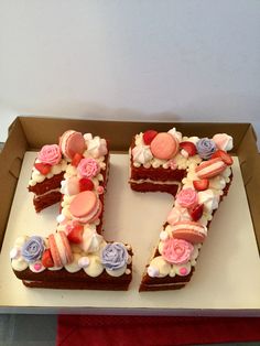 a cake shaped like the number seven with frosting and flowers on it in a box