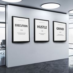 three black and white posters are hanging on the wall in an office space with glass doors