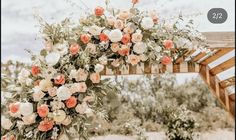 an outdoor wedding arch with flowers and greenery on it in front of the desert