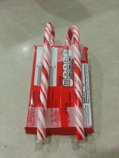 three candy canes sitting on top of each other in a package with labels attached to them