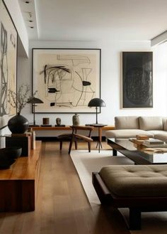 a living room filled with lots of furniture and art on the wall above it's coffee table