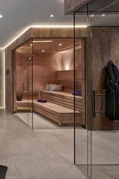 an indoor sauna room with wooden benches and glass walls