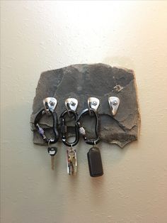 four keys are hanging on the wall with several locks attached to each key holder,