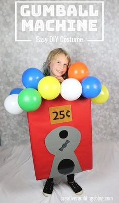 a child in a gumball machine costume with balloons