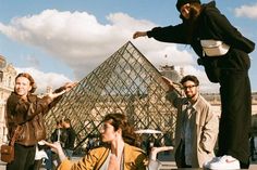 a group of people standing around in front of a pyramid