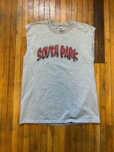 Here's a South Park T-shirt from the 1990s! Features cutoff sleeves and graffiti font. Gilden tag. Look Kool when wearing this T-shirt and stand out from the rest of the crowd. Condition: Good. No holes or stains. Sleeves have been cut off. Style: Y2K Brand: Gilden Color: Gray/Red Size: Large Refer to measurements Pit to pit: 20" Top to bottom: 27" Please don't hesitate to ask any questions. Thanks for looking! Tank T-shirt With Letter Print For Streetwear, Cotton Text Print Tank Top For Streetwear, Graphic Print Crew Neck Tank Top For Streetwear, Streetwear Graphic Tank Top With Crew Neck, Grunge Crew Neck Tank Top With Letter Print, Casual Sleeveless T-shirt With Logo Print, Y2k Streetwear Tank Top With Letter Print, Y2k Style Letter Print Tank Top For Streetwear, Graphic Tee Tank Top With Letter Print For Streetwear