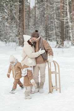 a woman and two children playing in the snow