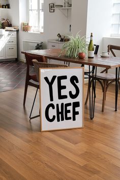 a sign that says yes chef sitting on the floor in front of a dining room table