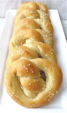 a white plate topped with rolls covered in sesame seeds