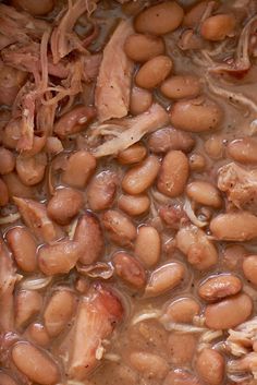 beans and meat are being cooked in a pot