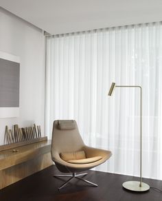 a living room with a chair, lamp and bookshelf