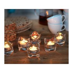 tealight candles are sitting on a wooden table