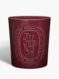 a red candle with the words tu ber u s e on it, and an oval