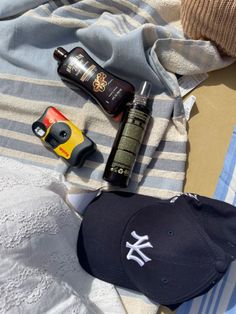 a baseball cap and other items are laid out on a towel next to a bottle of deodorant