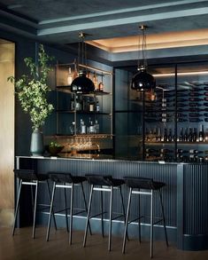 a bar with stools and bottles behind it