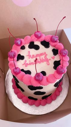 a pink and black birthday cake in a box