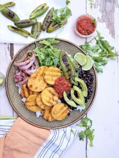 a plate filled with fried fish and vegetables next to sauces on a table top