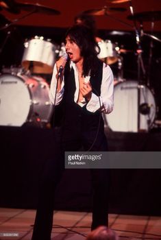 the rolling stones performing on stage in front of drummers and drums at an event