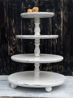 three tiered white cake stand on top of a wooden table