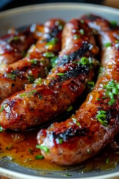 grilled sausages on a plate with sauce and parsley sprinkled around them