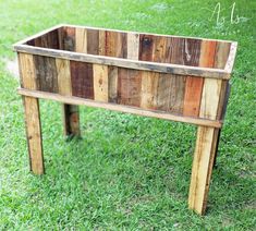 a wooden planter sitting on top of a lush green field