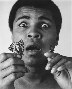 a man holding a butterfly in front of his face