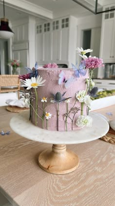 a pink cake decorated with flowers on a table