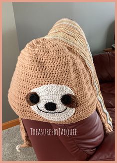 a crocheted slotty hat sitting on top of a leather chair