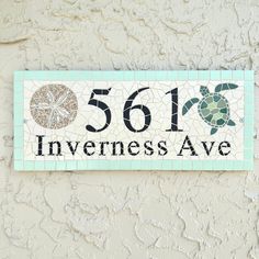 a sea turtle and sand dollar sign on the side of a building that says, 511 inventness ave