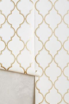 a white and gold wallpaper with an intricate design on it's sidewall