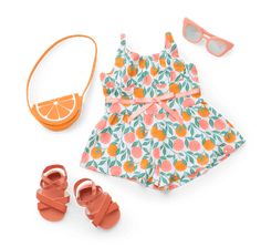 a dress and sandals are on display next to an orange wedge, sunglasses, and bag