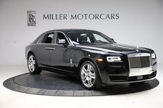 a black rolls royce parked in front of a wall with the words miller motorcars on it