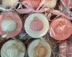 pink and white desserts in plastic wrappers with gold accents on them, sitting next to each other