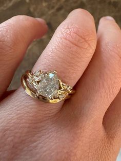 a woman's hand with a yellow gold ring on it and a white diamond in the middle