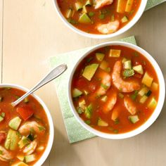 three bowls of soup with shrimp, avocado and tomato on the table top