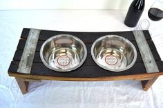 two stainless steel bowls sit on a wooden stand