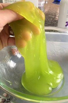 someone is pouring green liquid into a bowl