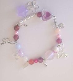 a bracelet with charms and beads on it, including a heart shaped beaded charm