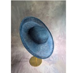 One sinamay straw hatinator base with an upturned brim in dark blue / light navy that measures approximately 15" (38cm) in diameter. Crown is approximately 3" (7.6cm) high. The edges of the brim are finished in wired sinamay. The multi-layer stiffened sinamay straw has a great sturdy weave and provides excellent support for your millinery creations. Sinamay is a natural material and you will see occasional beige / brown fibers / striations in the weave. This is not a defect, but is the result of how different natural fibers respond to dye and processing. This is NOT a ready to wear finished hat and will not stay on your head unless you add a head band or elastic to wear. This base does have a small sleeve sewn into the crown that will accomodate headbands listed separately in my shop. Add Adjustable Sinamay Boater Hat With Curved Brim, Adjustable Wide Brim Boater Hat For Church, Adjustable Curved Brim Boater Hat For Church, Adjustable Short Brim Boater Hat For Church, Adjustable Sinamay Boater Hat For Royal Ascot, Formal Sinamay Brimmed Boater Hat, Blue Wide Brim Fedora For Kentucky Derby, Adjustable Sinamay Straw Hat For Royal Ascot, Adjustable Brimmed Sinamay Hat