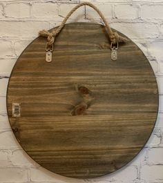 a round wooden sign hanging on a brick wall