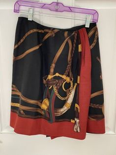 a skirt hanging up on a door with chains and rings attached to the bottom of it