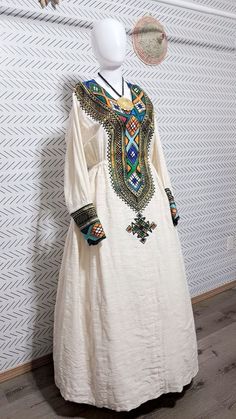 handmade fetel Mentwab Design .Introducing our Elegant Habesha Dress, a stunning piece that combines traditional Ethiopian design with modern elegance. This beautiful white dress features intricate and colorful embroidery, adding a touch of sophistication to any wardrobe. With a classic silhouette and delicate button detailing, this dress is perfect for special occasions or everyday wear. Elevate your style with the timeless beauty of the Habesha Dress. Bohemian Style Habesha Kemis Maxi Length, Traditional Maxi-length Agbada For Ceremonies, Traditional Maxi Length Agbada For Ceremonies, Habesha Dress, Beautiful White Dress, Ethiopian Women, Habesha Kemis, Hebrew Israelite, Beautiful White Dresses