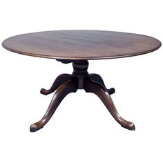 an oval wooden table with four leaves on the top and two legs, sitting against a white background