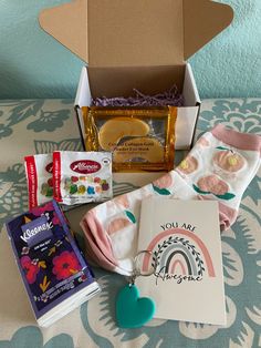 the contents of a baby's gift box are laid out on top of a bed